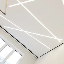 Світлові лінії натяжної стелі, що перетинаються під кутом у сучасному стилі